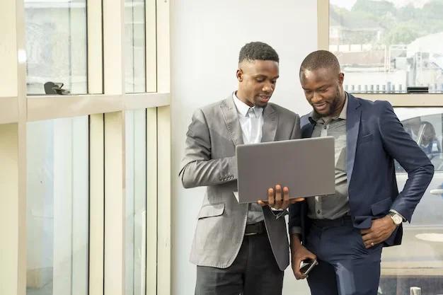 Entity Support and Management 3 young businessmen standing together holding laptop discussing business 181624 46531
